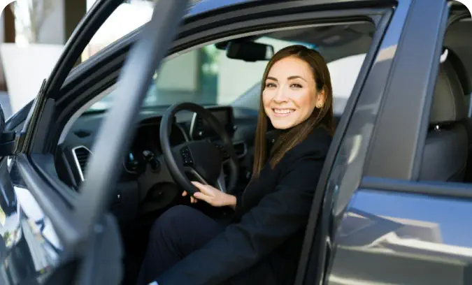 Una mujer ingresando en su nuevo auto